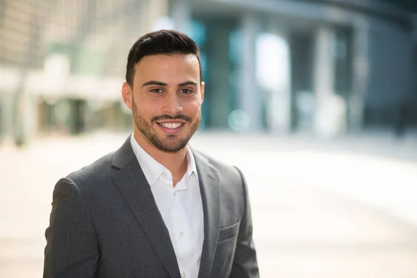 Hombre de negocios sonriente en el entorno empresarial — Foto de Stock