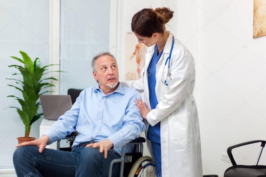Doctor taking care of patient on wheelchair