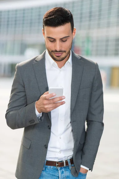 Pewny siebie człowiek biznesu przy użyciu smartfona — Zdjęcie stockowe