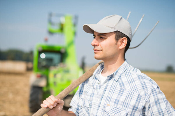 smiling farmer holding a pitchfork