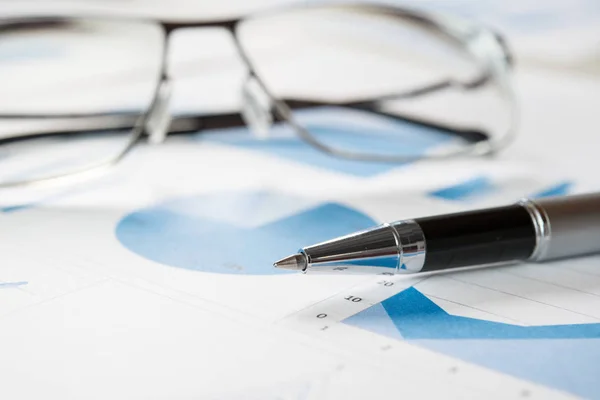 Ручка та окуляри на фінансових документах — стокове фото