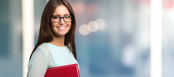 Sorrindo mulher segurando um livro — Fotografia de Stock