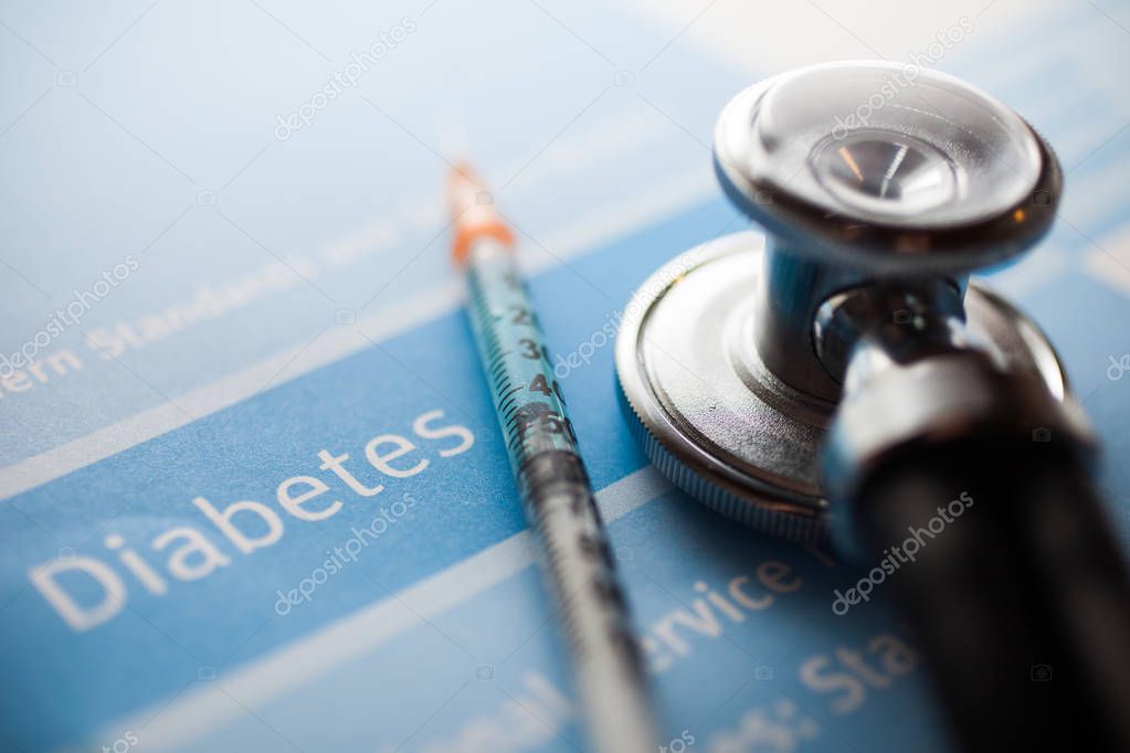 Stethoscope and syringe on diabetes test