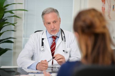 Doktor hastasını dinliyor.