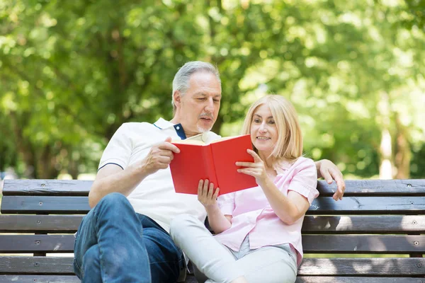 Casal maduro lendo um livro ao ar livre — Fotografia de Stock