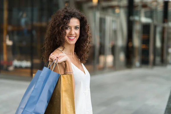 Usmívající se žena drží nákupní tašky — Stock fotografie