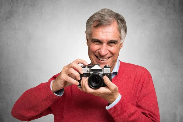 Hombre maduro sosteniendo una cámara vintage — Foto de Stock