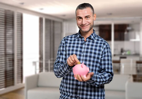 Man putting savings in piggy bank — Stock Photo, Image