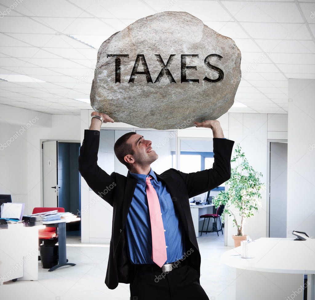 businessman holding stone with taxes word