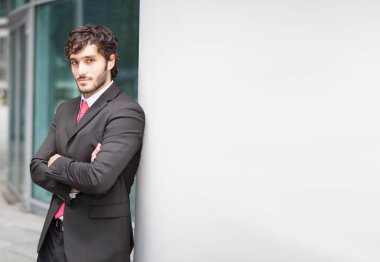Beyaz duvara yaslanmış işadamı