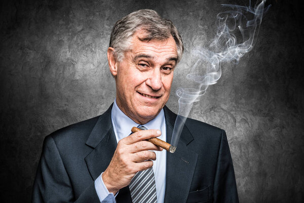 senior businessman smoking a cigar