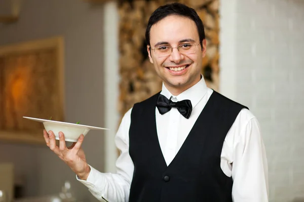 Улыбающийся официант в ресторане — стоковое фото