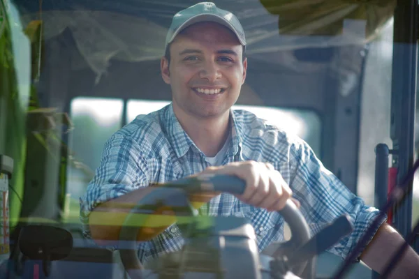 Agricultor dirigindo uma máquina de colheita — Fotografia de Stock