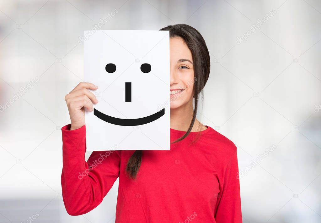 girl covering her face with paper 