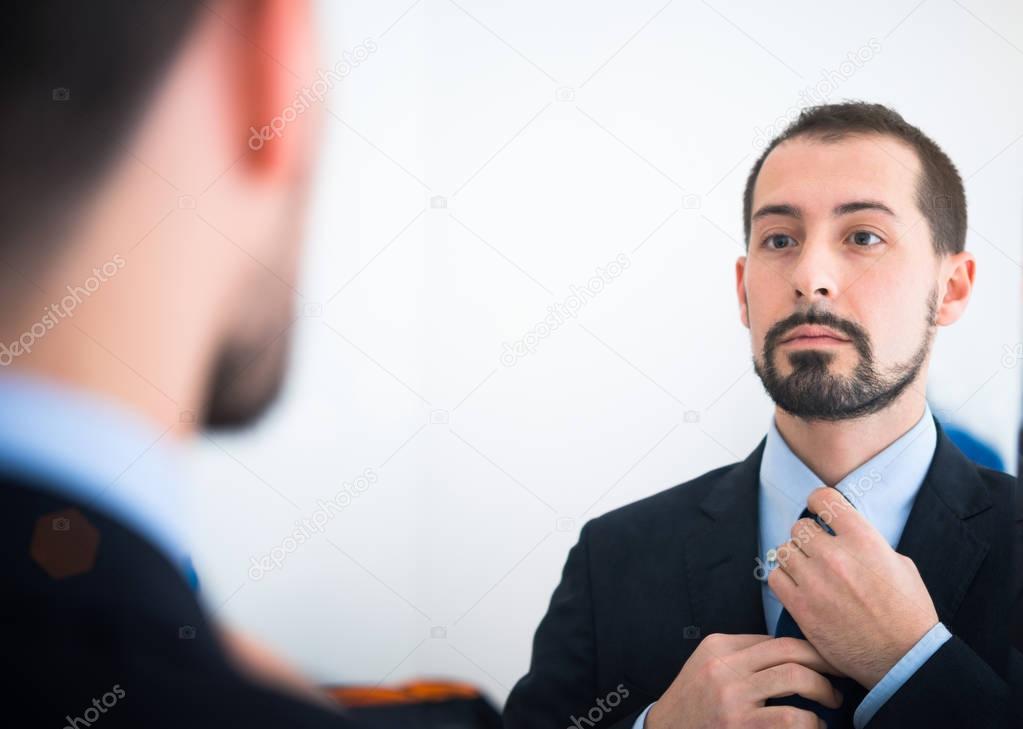 businessman looking at himself in mirror