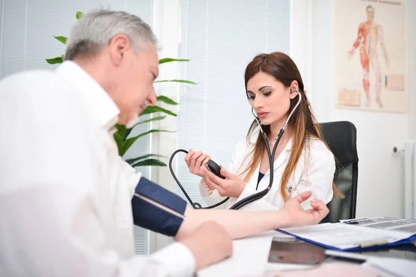 Medico masticazione pressione sanguigna paziente — Foto Stock