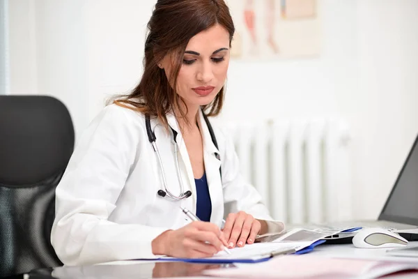 Doctor doing paperwork in office — Stock Photo, Image