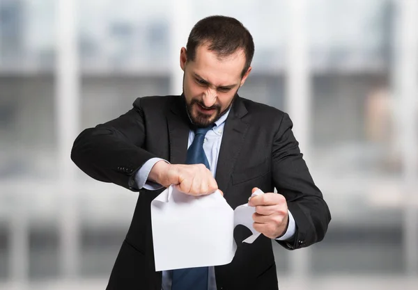 Angry businessman tearing up document — Stock Photo, Image