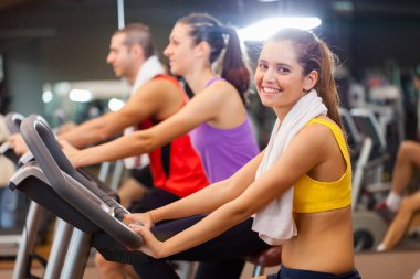 Spor salonunda spor yapan bir grup insan.