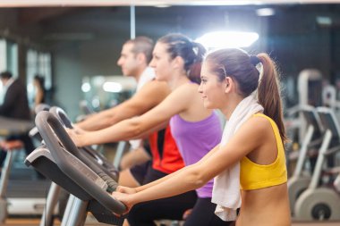Spor salonunda spor yapan bir grup insan.
