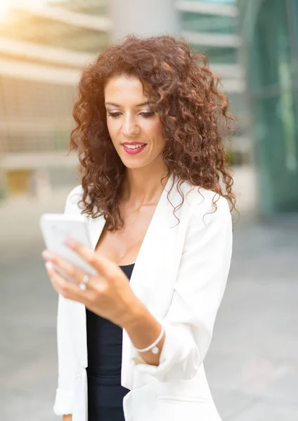 Leende kvinna som använder telefon — Stockfoto