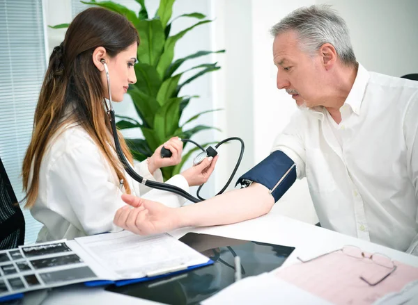 Médico mastigando pacientes pressão arterial — Fotografia de Stock