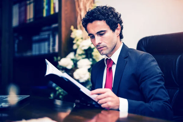 Бизнесмен читает в офисе — стоковое фото