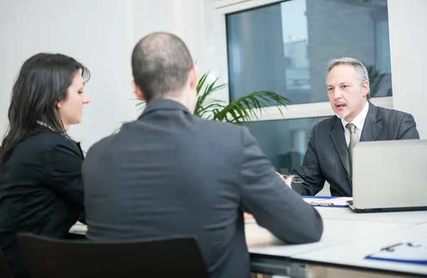 Zakenman praten met paar — Stockfoto