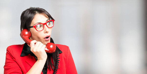 Amazed woman using vintage phone