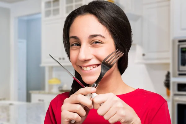 Adolescente com fome segurando garfo e faca — Fotografia de Stock
