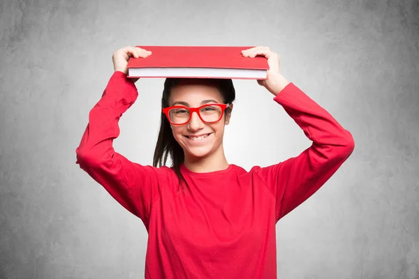 Student holding book over head — Stock Photo, Image