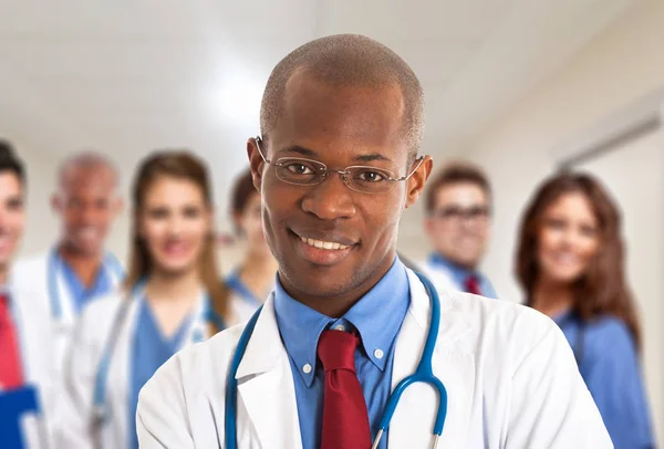 Leende läkare framför kollegor — Stockfoto