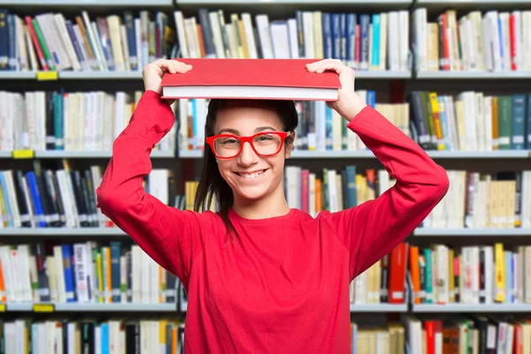 Lachende tiener student in bibliotheek — Stockfoto