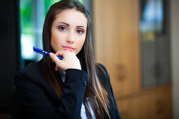 Joven empresaria sosteniendo pluma — Foto de Stock