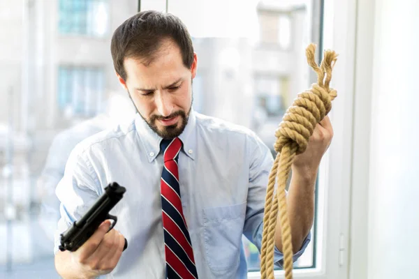 Businessman choosing between gun or loop — Stock Photo, Image