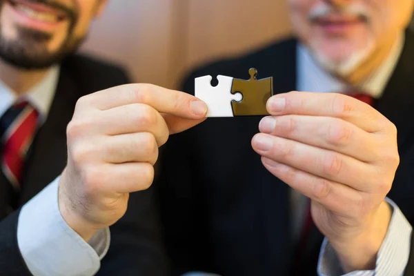 Zakenmannen holding puzzels in kantoor — Stockfoto