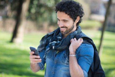 Bir parkta telefonu kullanan adam