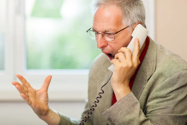 Старший бизнесмен кричит по телефону — стоковое фото