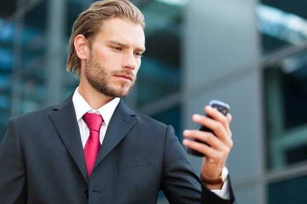 Bonito homem de negócios usando telefone — Fotografia de Stock