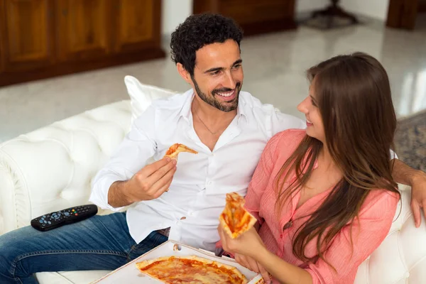 テレビを見ながらピザを食べるカップル — ストック写真