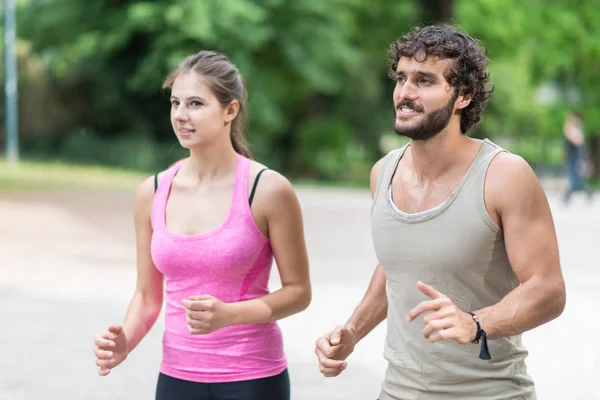 Couple running in a park — Stock Photo, Image