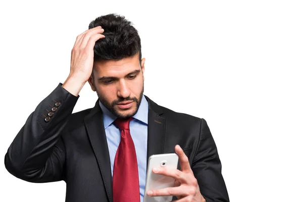 Обеспокоенный мужчина смотрит в смартфон — стоковое фото
