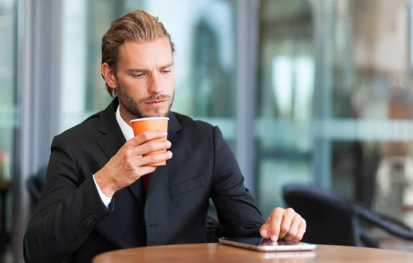 Empresario beber café y el uso de la tableta — Foto de Stock