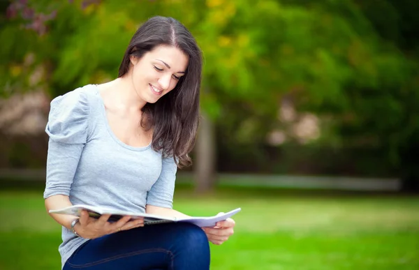 Student reading book in park — Stock Photo, Image