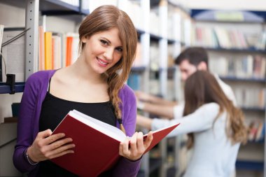 Kütüphanede gülümseyen öğrenci