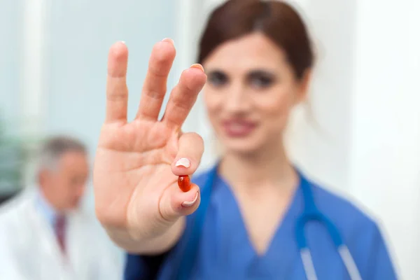 Enfermera sosteniendo píldora en la mano —  Fotos de Stock