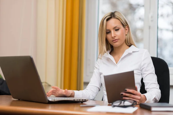 Nő segítségével a laptop és a tabletta a munkahelyi — Stock Fotó