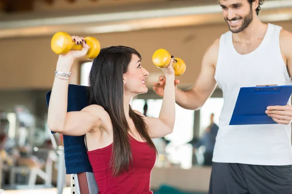 Frau stemmt Gewichte im Fitnessstudio — Stockfoto