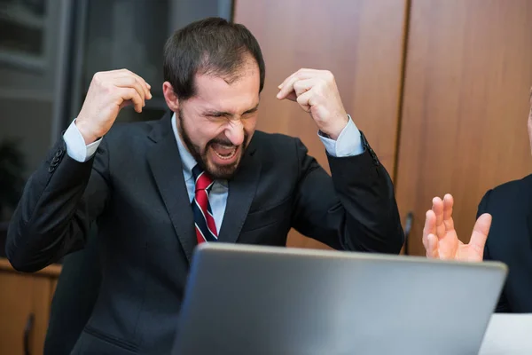 Разгневанный бизнесмен кричит в офисе — стоковое фото