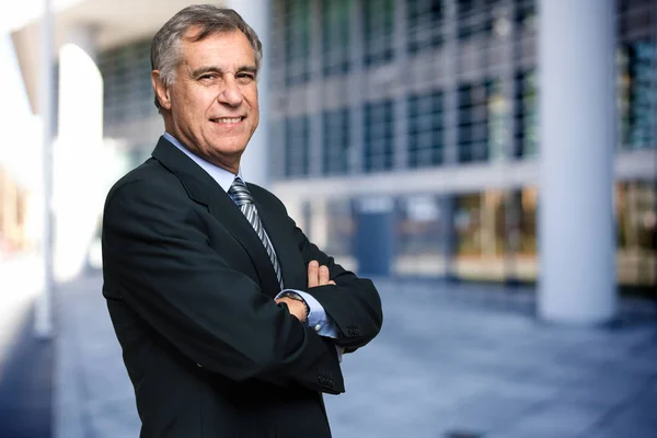 Guapo hombre de negocios brazos cruzados al aire libre — Foto de Stock